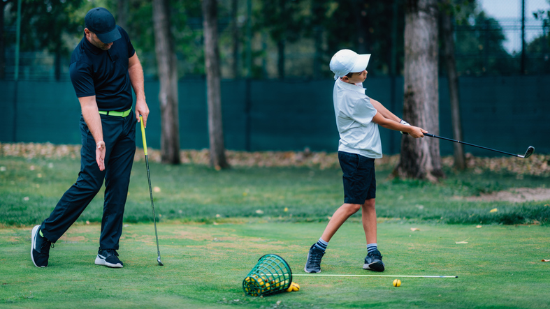 Golf – Personal Training. Golf Instructor Teaching Young Boy How to Play Golf.