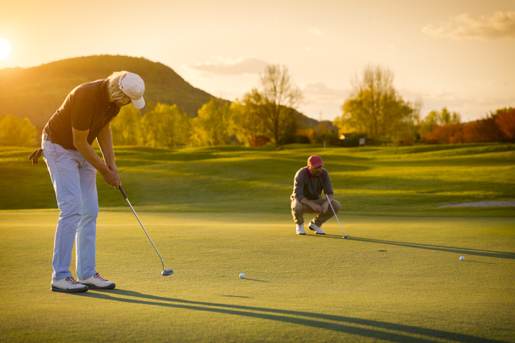 Two senior golf player at sunset.
